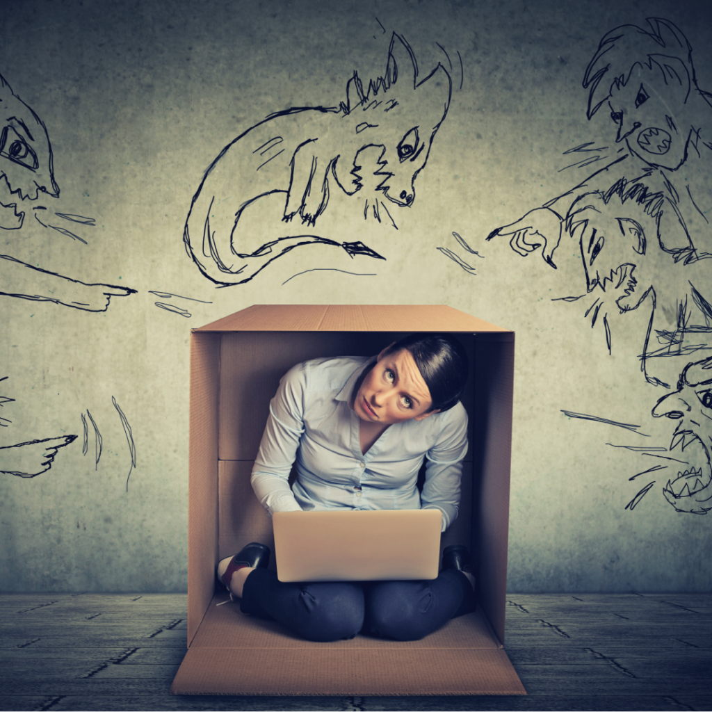 beholdher.life blog no 7 the mother-guilt effect work life balance guilt a woman hiding in a box with angry cartoons pointing and yelling at her