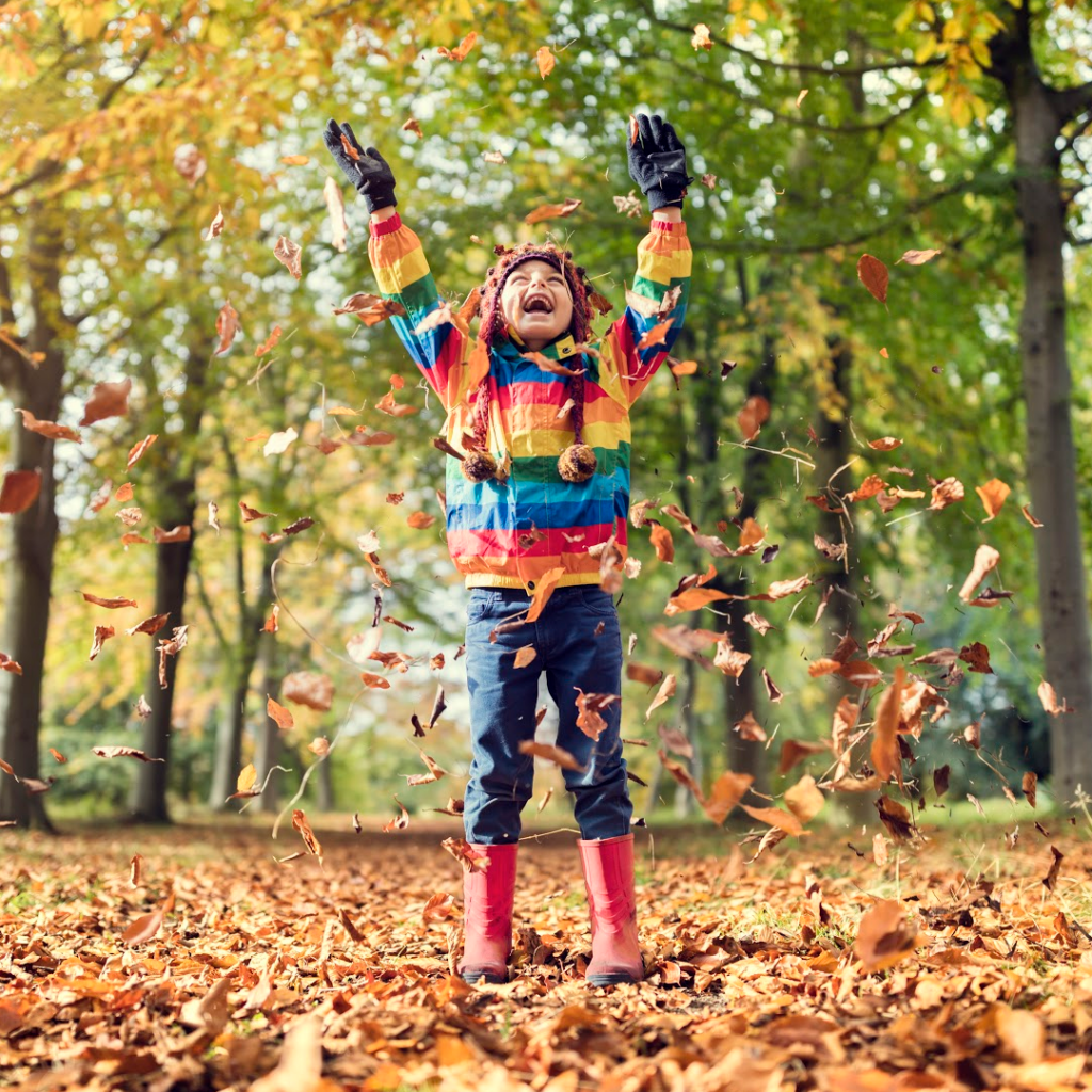 beholdher.life  - child playing in the Autumn Leaves - article about Gratitude and Giving Thanks